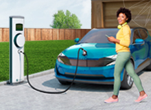 young woman in front of her electric car while it's charging